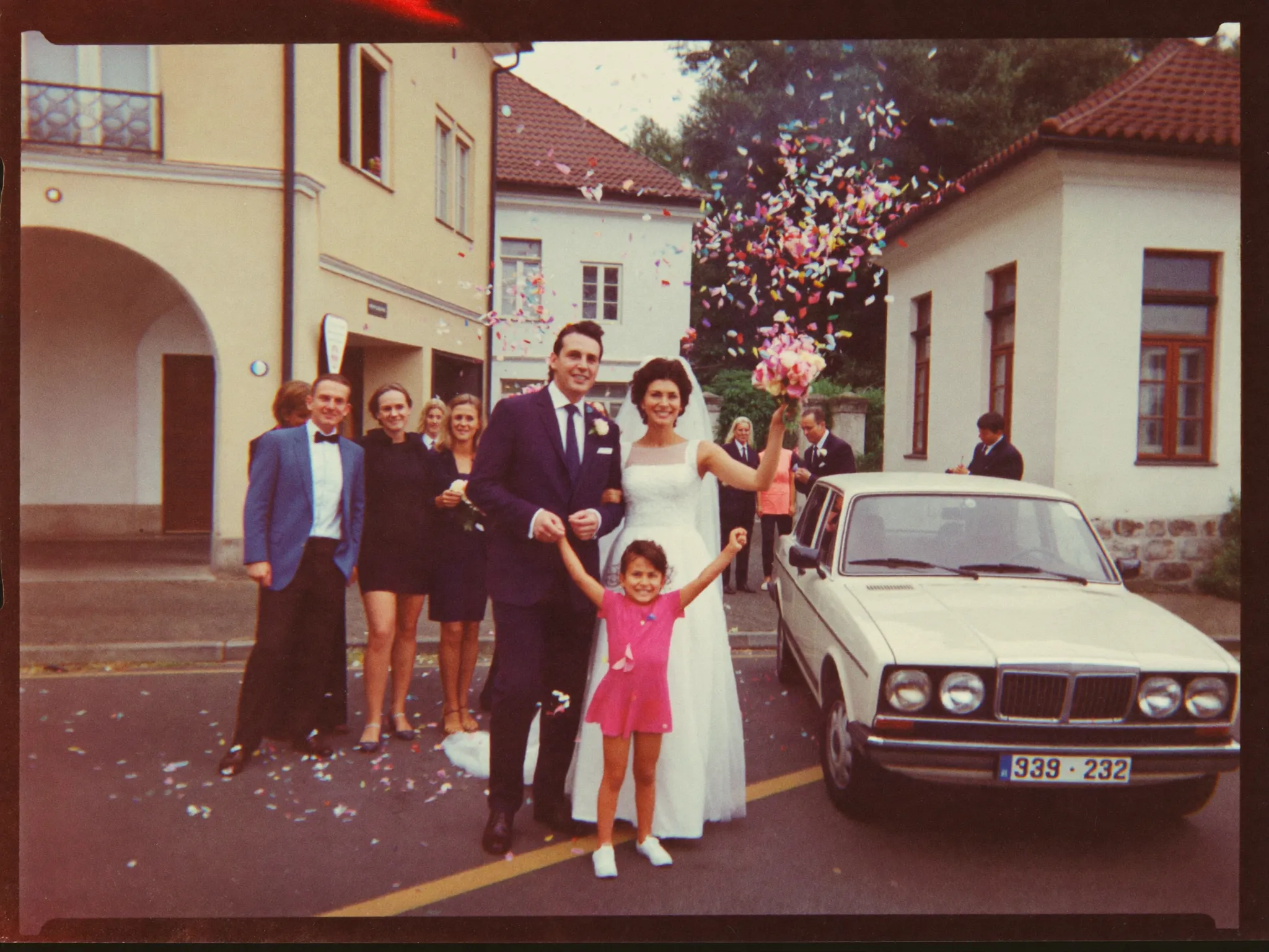 Svatební fotografie z roku 1981 — novomanželé před radnicí, konfety ve vzduchu